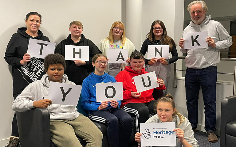 A group of young people, part of Grimsby Youth Zone's Young People's Development Group hold a Thank You sign, to thank The National Lottery Heritage Fund for their support